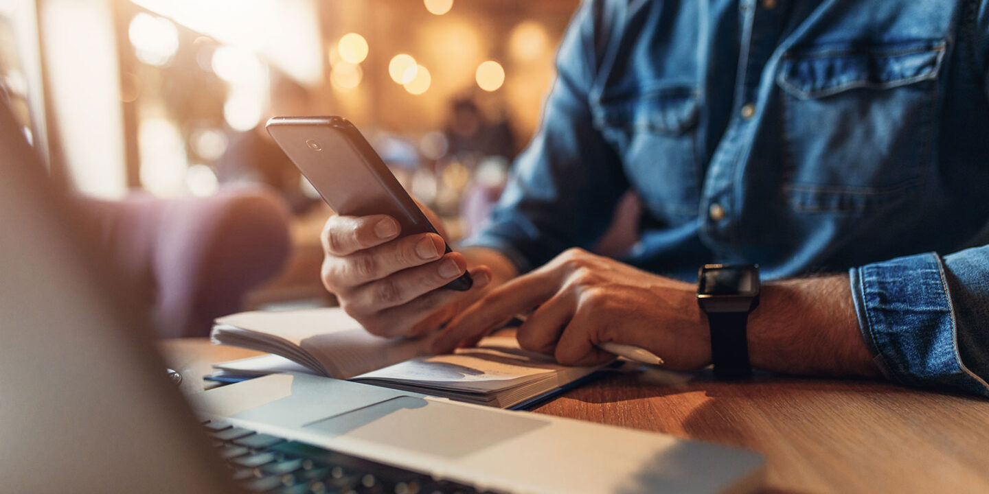 Business man texting clients on his phone.