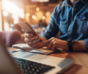 Business man texting clients on his phone.