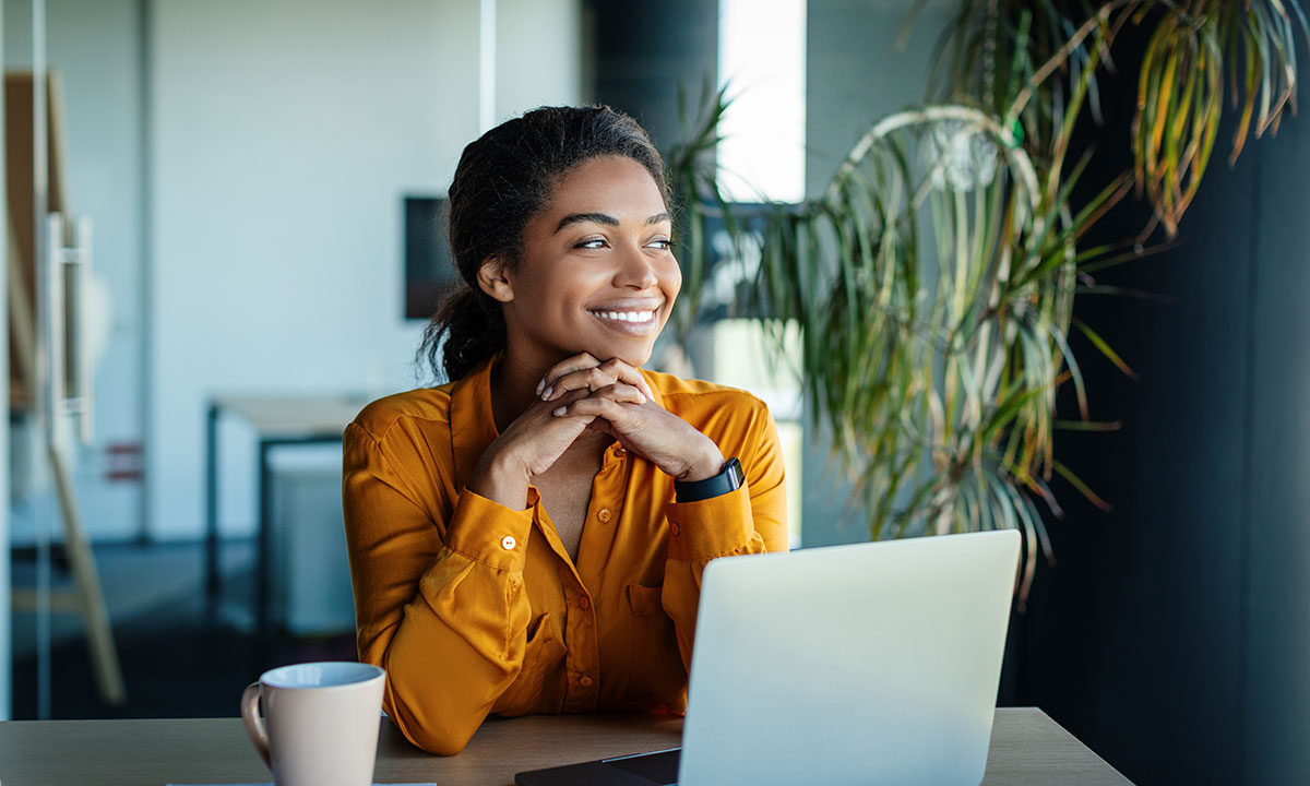 Small business owner smiling while working on a laptop, representing a positive client experience