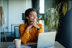 Small business owner smiling while working on a laptop, representing a positive client experience