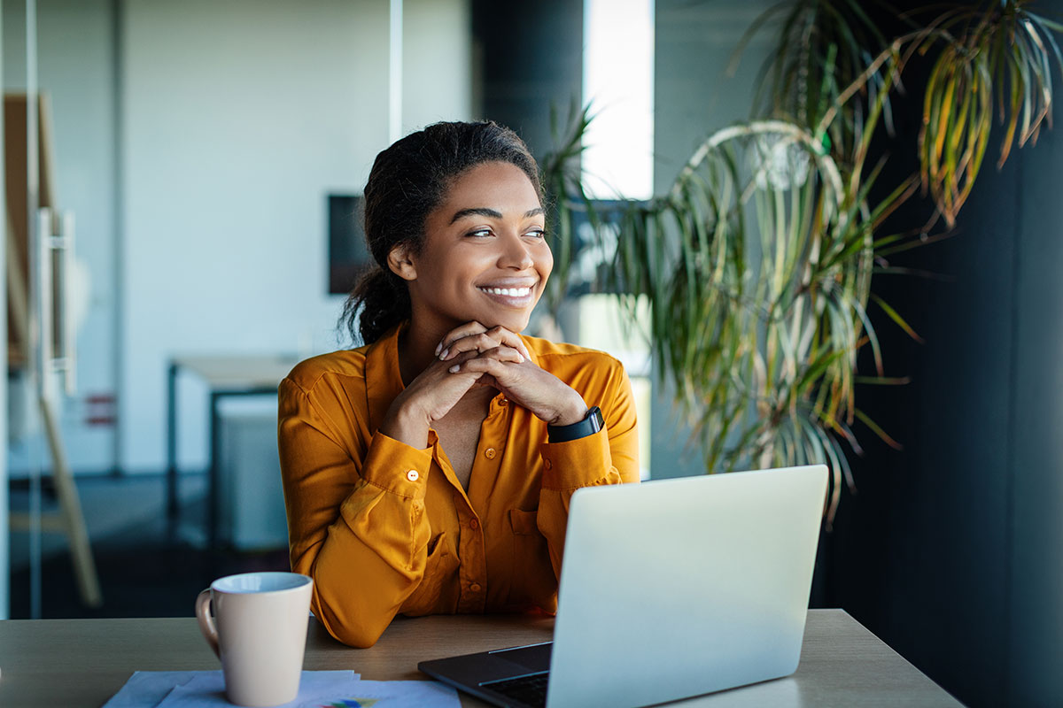 Small business owner smiling while working on a laptop, representing a positive client experience