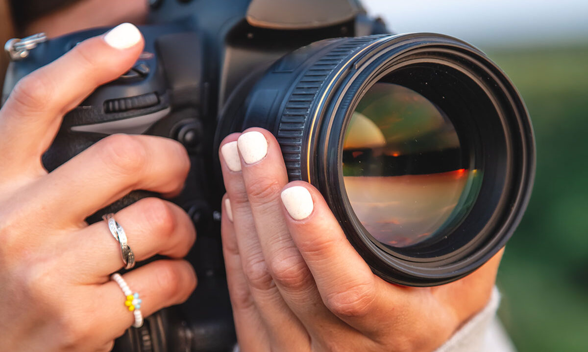 Photographer holding a camera, illustrating an Iris Works vs. 17hats client management software comparison