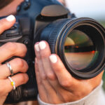 Photographer holding a camera, illustrating an Iris Works vs. 17hats client management software comparison