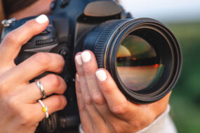 Photographer holding a camera, illustrating an Iris Works vs. 17hats client management software comparison