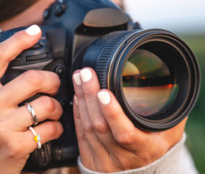 Photographer holding a camera, illustrating an Iris Works vs. 17hats client management software comparison