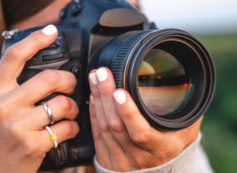 Photographer holding a camera, illustrating an Iris Works vs. 17hats client management software comparison
