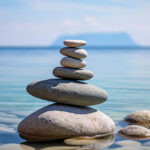 Stack of balanced smooth stones in calm shallow water, representing work-life balance for small business owners