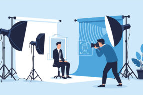 Illustration of a headshot studio with softbox lighting, a seated subject in a suit, and a photographer